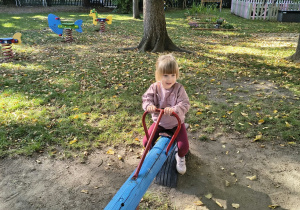 Dziewczynka na huśtawce w ogrodzie przedszkolnym