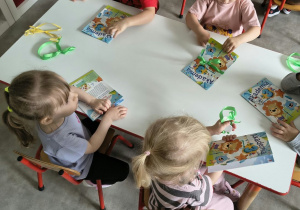 Dzieci oglądają upominki otrzymane od solenizantki