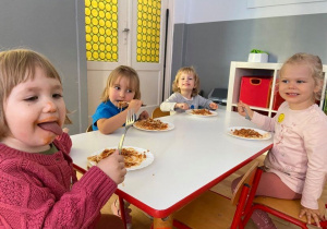 Dziewczynki siedzą przy stoliku i jedzą obiad - spaghetti