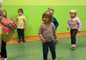 Dzieci tańczą do muzyki na sali gimnastycznej