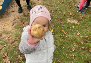 Dziewczynka pokazuje znalezionego ziemniaka