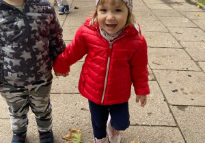 Dziewczynka i chłopiec uśmiechający się do zdjęcia podczas spaceru.