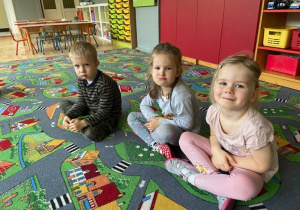 Dzieci na dywanie pokazują smutną minę