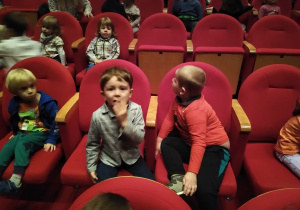 dzieci siedzą na fotelach w teatrze