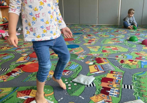 Dziewczynka pokonuje tor przeszkód na dywanie