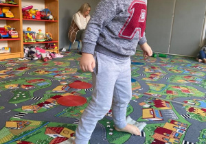 Chłopiec pokonuje tor przeszkód na dywanie