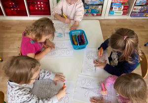 Dzieci przy stolikach kolorują kolorowanki z motywem Francji