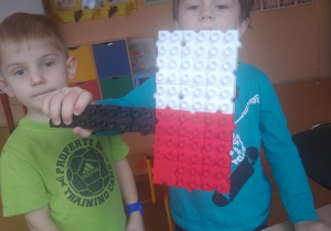 dzieci z flagą Polski zrobioną z klocków