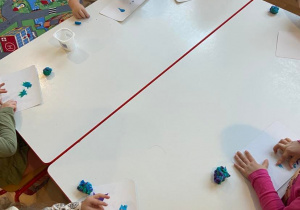 Dzieci przy stoliku lepią z plastliny