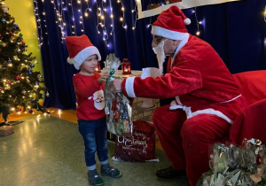 Chłopiec odbiera prezent od Świętego Mikołaja