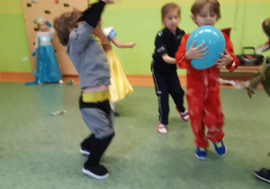 Sala gimnastyczna. Bal karnawałowy. Dzieci w przebraniach tańczą z balonami..