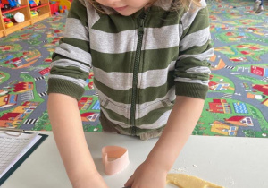 Chłopiec wycina ciasteczka z formy w kształcie serca