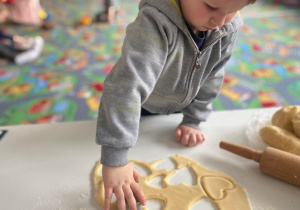 Chłopczyk wycina ciasteczka z formy w kształcie serca