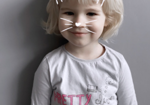 Dziewczynka z filtrem - maską kota uśmiecha się do zdjęcia