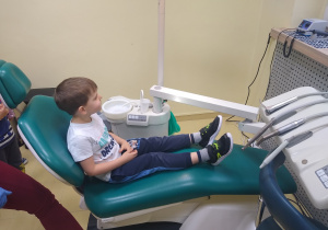 chłopiec siedzi na fotelu dentystycznym