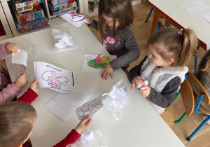 Dzieci w sali przy stolikach wykonują pracę plastyczną "Ząbek"
