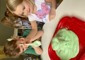 dzieci robią kolorowe wulkany z octu, sody i barwnika