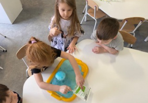 dzieci robią kolorowe wulkany z octu, sody i barwnika
