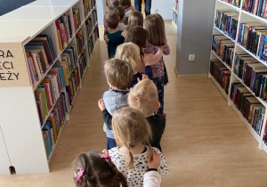 Dzieci ustawione w pociąg zwiedzają blibliotekę