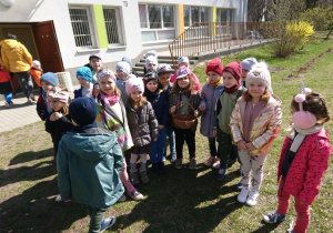 Ogródek przedszkolny. Grupa dzieci wyrusza na poszukiwanie ukrytych przez Zajączka Wielkanocnego słodyczy. Pokazują pusty koszyk.