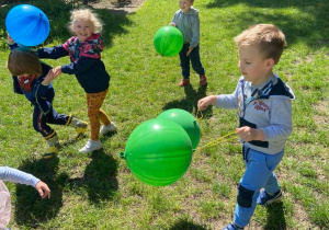 Dzieci w ogrodzie przedszkolnym bawią się balonami