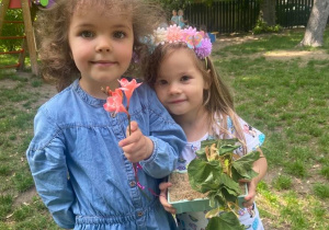 Dziewczynki pozują do zdjęcia z kwiatami
