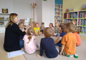 pani Gabrysia pokazuje dzieciom ilustracje w książce o Fenku