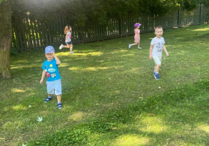 Dzieci biegają po ogrodzie przedszkolnym