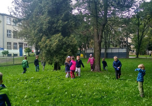 dzieci sprzątają teren wokół przedszkola