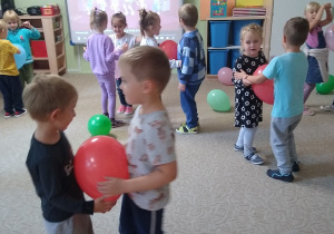 dzieci tańczą w parach z balonami trzymając je między brzuszkami