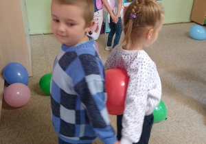 dzieci tańczą w parach z balonami trzymając je pomiędzy swoimi plecami