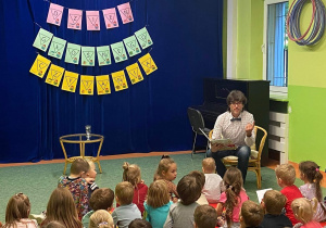dzieci słuchają książki czytanej przez Skrzata Makówkę