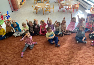 Dzieci na dywanie pokazują obrane jabłka