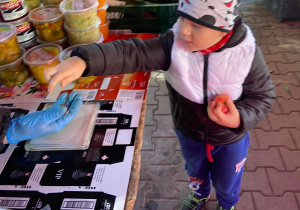 Chłopiec kupujący jabłko na okolicznym ryneczku