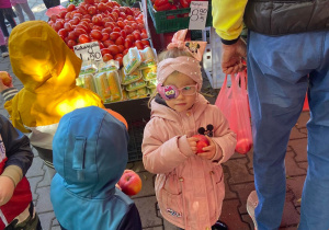 Dzieci z zakupionymi jabłkami w dłoniach
