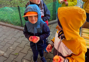 Dzieci trzymające w dłoniach zakupione jabłka