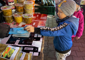 Chłopiec kupujący jabłko na okolicznym ryneczku