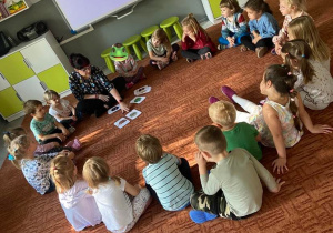 Dzieci na dywanie uczą się zwrotów w języku niemieckim