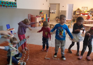 Dzieci bawią się, tańczą z kolorowymi serpentynami.