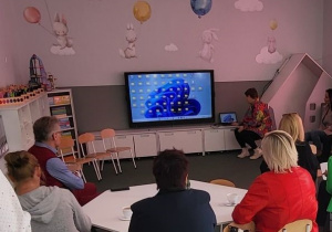 Dyrektorzy oglądający prezentacje drukarek 3D na monitorze interaktywnym