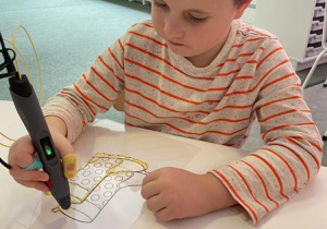 Chłopiec rysuje pisakiem 3d kalosze