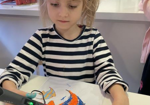 Dziewczynka rysuje rybę