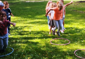 Dzieci biegają w ogrodzie przedszkolnym.