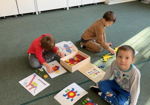 chłopcy układają obrazki z mozaiki geometrycznej wg wzoru