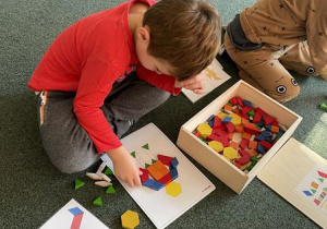 chłopcy układają obrazki z mozaiki geometrycznej wg wzoru