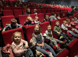 dzieci siedzą na widowni w sali teatralnej