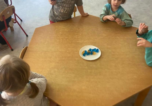Dzieci przy stoliku jędzą niebieskie galaretki