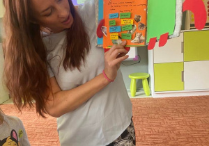 Mama jednej z dziewczynek pokazuje książkę z zasadami zabawy z kotem