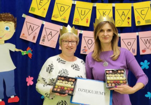 Nauczycielki w koronach na głowach prezentują napis Dziękujemy i czekoladki z napisem Sówki