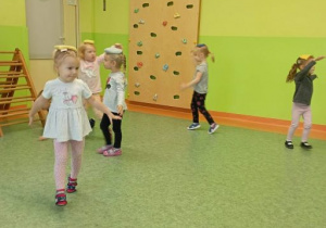 Dzieci starają się utrzymać równowagę chodząc z woreczkami gimnastycznymi położonymi na głowach